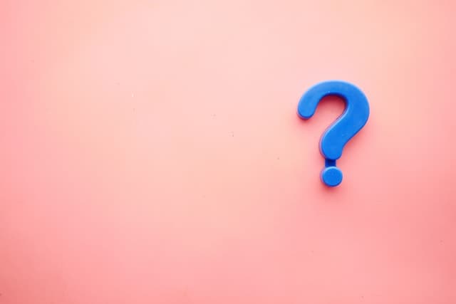 Blue fridge magnet question mark on a pink background